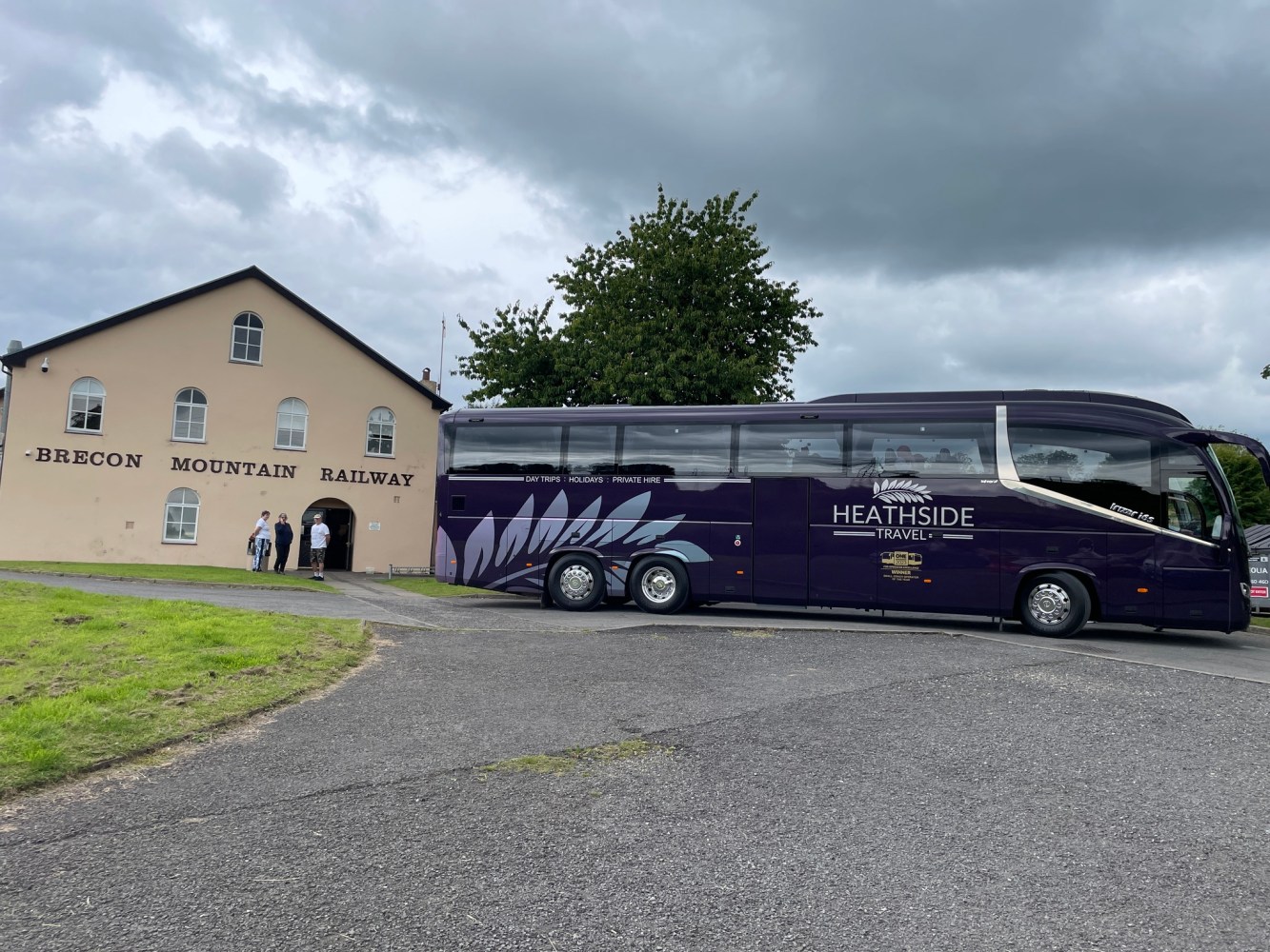 a tcoach is parked on the side of a building